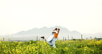 Love, couple and hug on field for celebration, care and romance with space on holiday. Embrace, man and woman in countryside with flowers on vacation, anniversary and bonding together outdoor