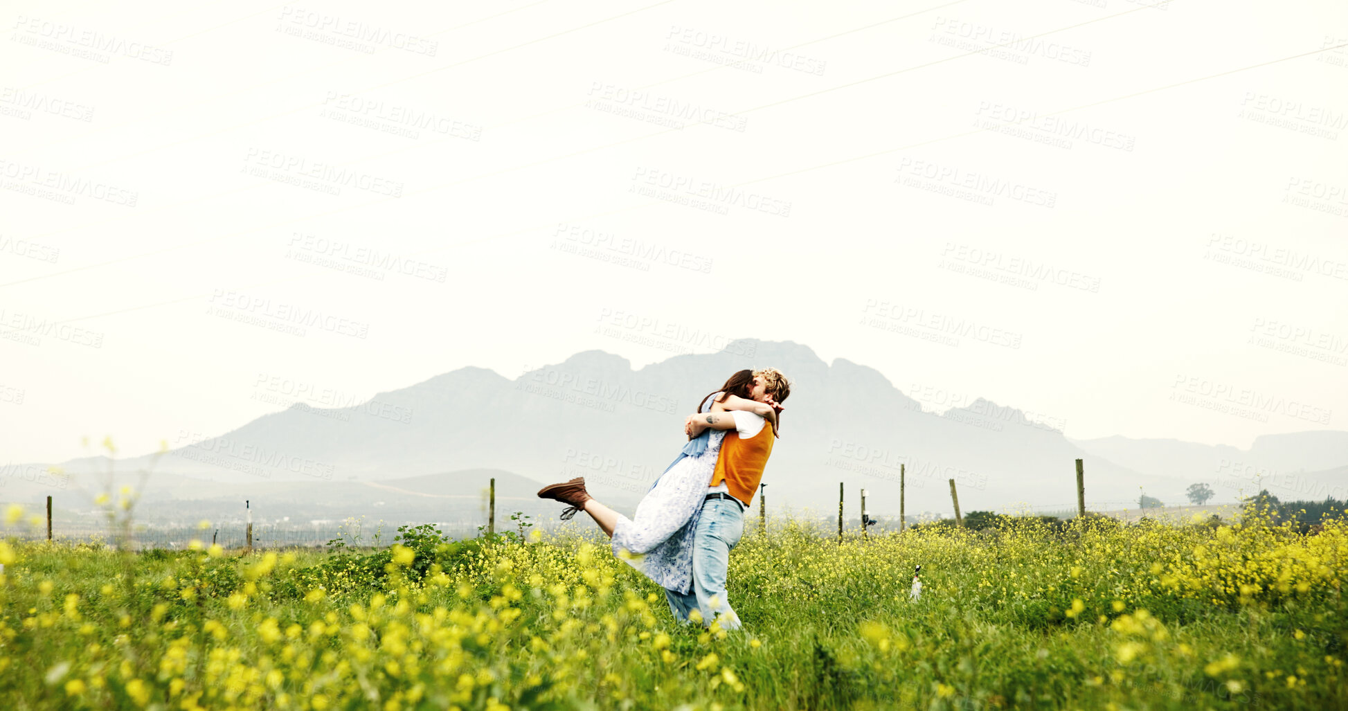Buy stock photo Love, couple and hug on field for celebration, care and romance with space on holiday. Embrace, man and woman in countryside with flowers on vacation, anniversary and bonding together outdoor