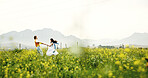 Canola farm, running and couple in nature for adventure, fun and exploring together on summer holiday. Field, outdoor and man with woman for bonding in flower environment in countryside for vacation.