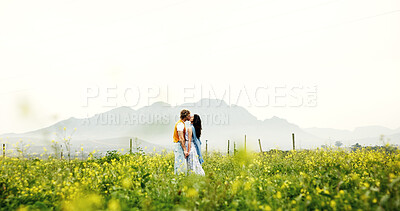 Buy stock photo Love, couple and kiss on field for connection, care and holding hands with space on holiday. Romance, man and woman in countryside with flowers on vacation, commitment and bonding together outdoor