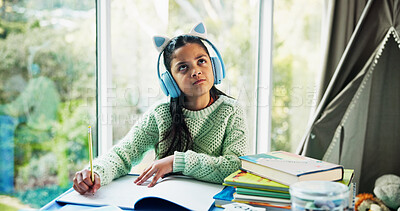 Buy stock photo Headphones, thinking and writing with girl student at desk in home for development or learning. Education, homework and notebook with child learner streaming music in apartment for knowledge or study