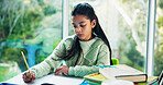 Education, homework and notebook with girl student at desk n home for development or learning. Growth, school study and writing with child learner in apartment for assessment, knowledge or solution