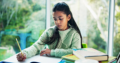 Buy stock photo Education, homework and notebook with girl student at desk n home for development or learning. Growth, school study and writing with child learner in apartment for assessment, knowledge or solution