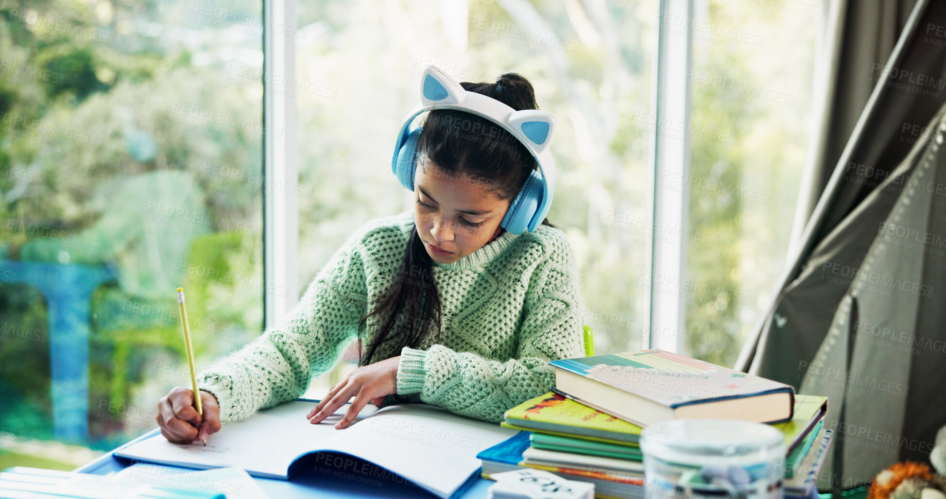 Buy stock photo Education, headphones and notebook with girl student at desk n home for development or learning. Homework, music and writing with child learner in apartment for assessment, knowledge or solution