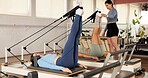 Reformer, fitness and women in studio, stretching and pilates class with resistance. Healthy people, machine and group in wellness center, instructor and endurance with exercise, workout and routine