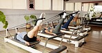 Reformer, stretching and women in studio, training and pilates class with endurance. Healthy people, machine and group in wellness center, equipment and resistance with exercise, workout and fitness