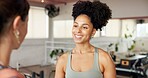Women, personal trainer and talking to client in gym, conversation or listening to positive feedback. Happy, people and instructor with fitness tips, advice and discussion on break in health club