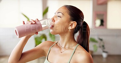 Buy stock photo Fitness, drinking water and woman in studio, indoor exercise and hydration on workout break. Thirsty, refreshing liquid and person gulp from bottle for recovery, yoga pause and rest in health club.