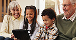 Tablet, happy and grandparents with children on sofa in home for watching movie, series or show. Relax, digital technology and senior people with kids for streaming film together in living room.