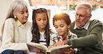Home, reading and grandparents with children on sofa for bonding, learning together and knowledge. Flare, family and happy grandpa, grandma and kids with books, literature and story for education
