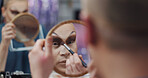 Drag artist, mirror and makeup in dressing room for beauty, self expression and makeover. LGBTQ performer, person and apply cosmetics with brush for preparation, eyeshadow or reflection for aesthetic