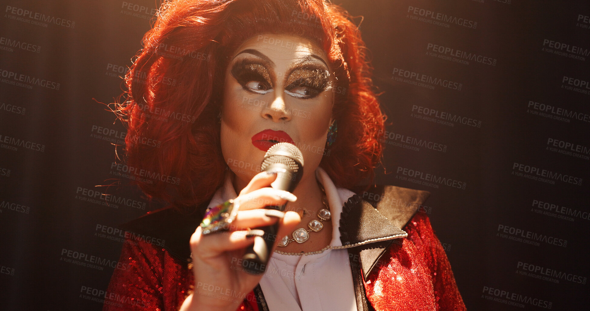 Buy stock photo Person, drag artist and singing at concert, stage and spotlight with pride, music and event. Lgbt performer, creative and voice with celebration, song and makeup with microphone at cabaret show
