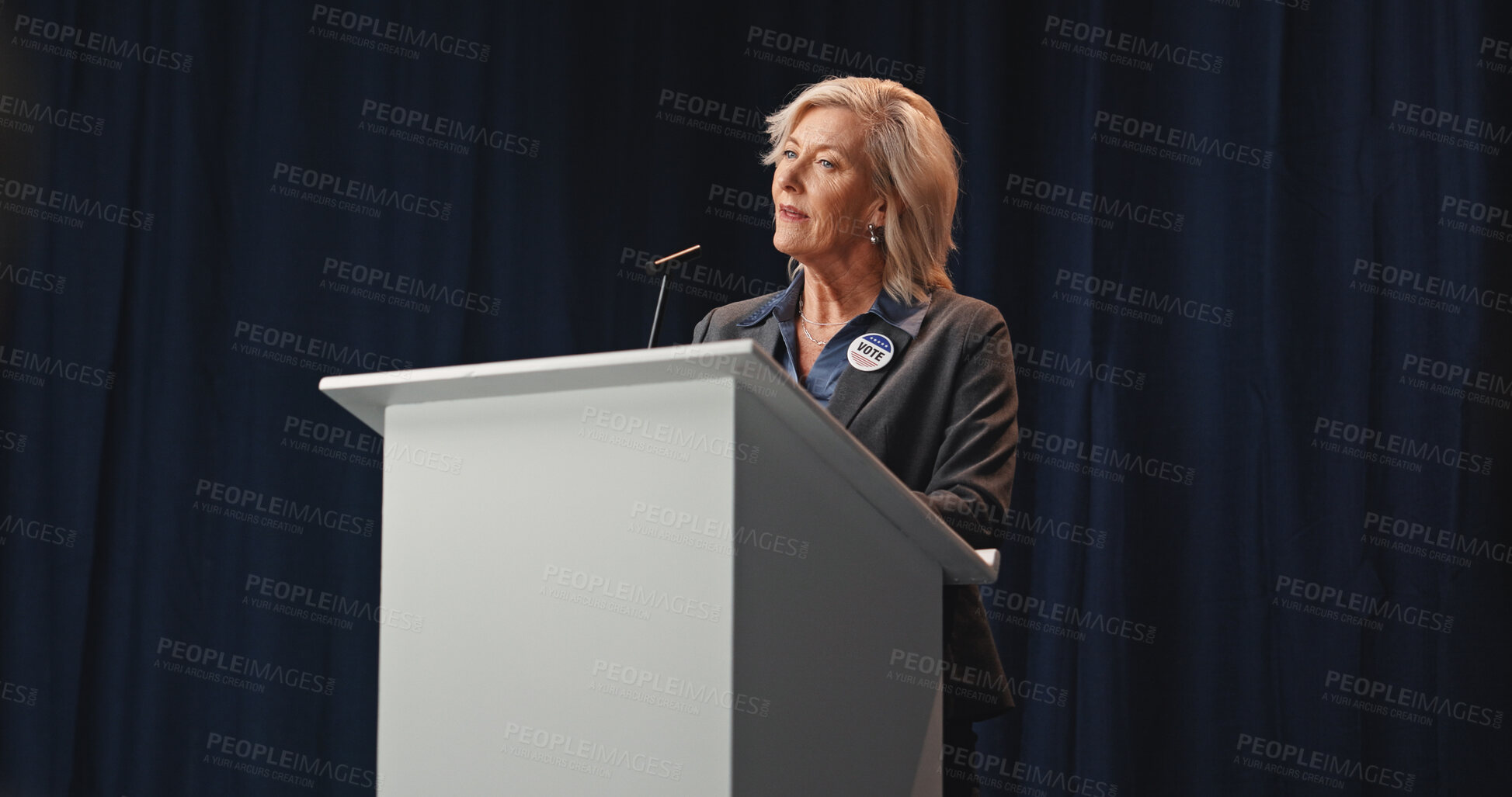 Buy stock photo Election, politician or woman at podium with mic, democratic process or candidate speech at debate. Campaign message, persuasion or mature person with call to action, voter trust or public engagement