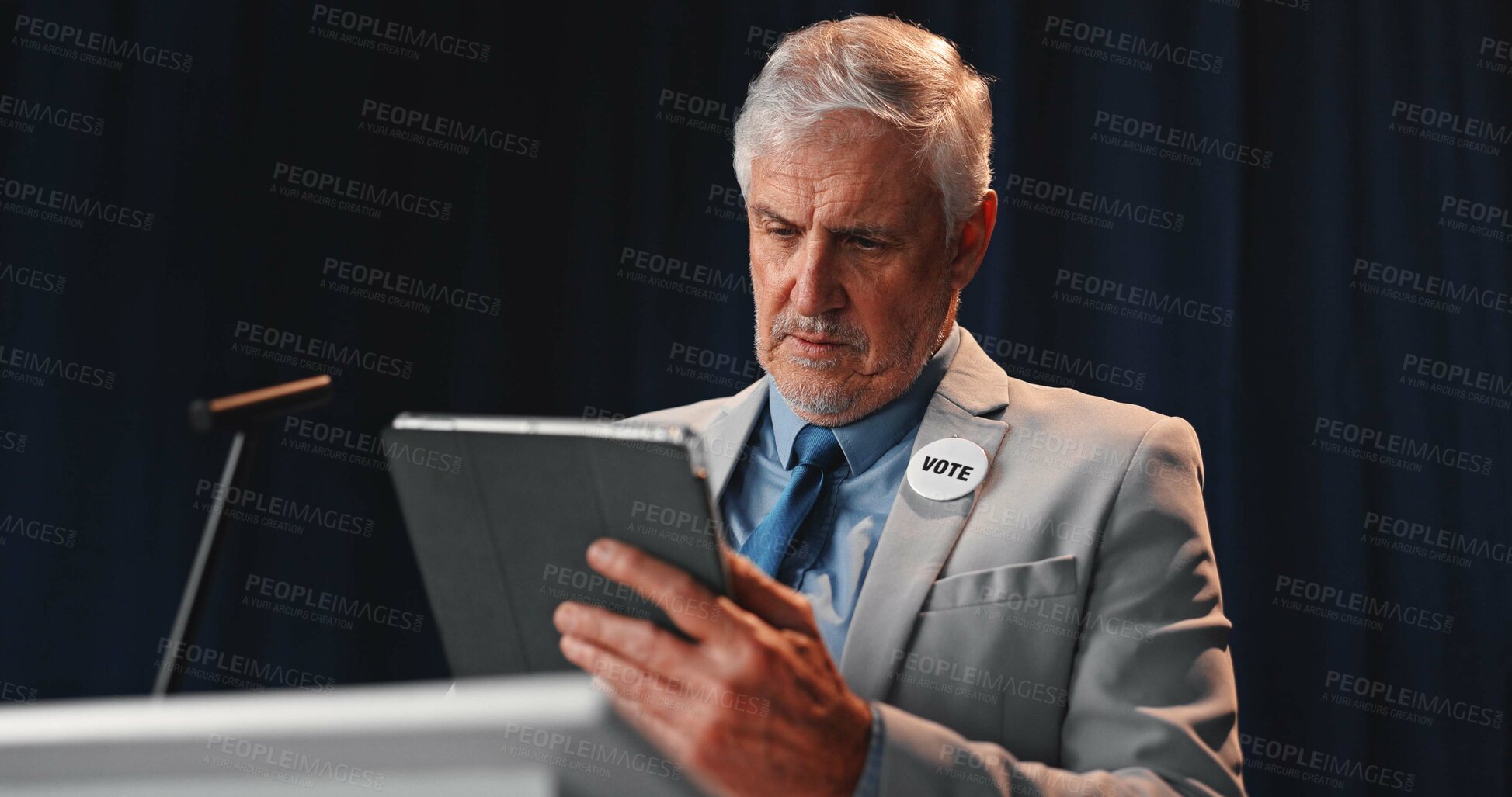 Buy stock photo Podium, politician and man on tablet for speech notes, election debate and prepare on stage. Government, candidate and mature person on digital tech for political agenda, voting stats and planning