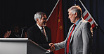 Men, handshake and flags with agreement, stage or happy for trade partnership, success or tariff deal. People, USA and China with global leader, shaking hands and smile with crowd applause at seminar