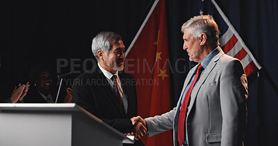 Buy stock photo Men, handshake and flags with agreement, stage or happy for trade partnership, success or tariff deal. People, USA and China with global leader, shaking hands and smile with crowd applause at seminar