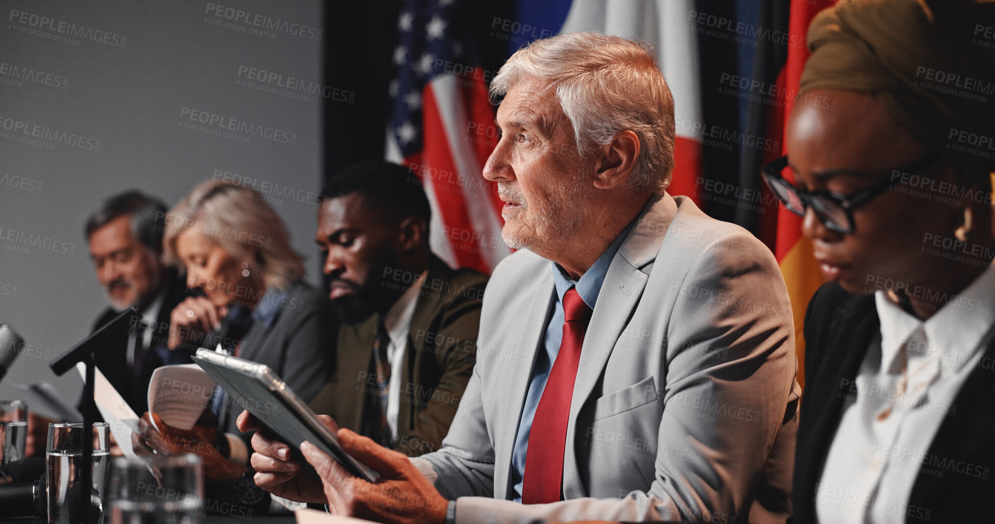 Buy stock photo Press conference, tablet and man with group for delegation, international government and panel. Summit, people and politician at speech event for diplomacy discussion, global forum or policy update