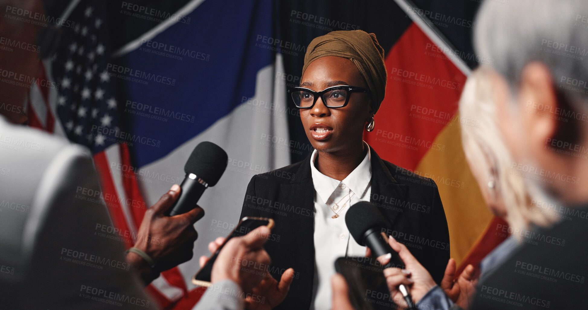 Buy stock photo Woman, press conference and flags at international seminar, journalist group or interview at event. Person, speaker or ambassador with media, mic and announcement for peace negotiation for global war