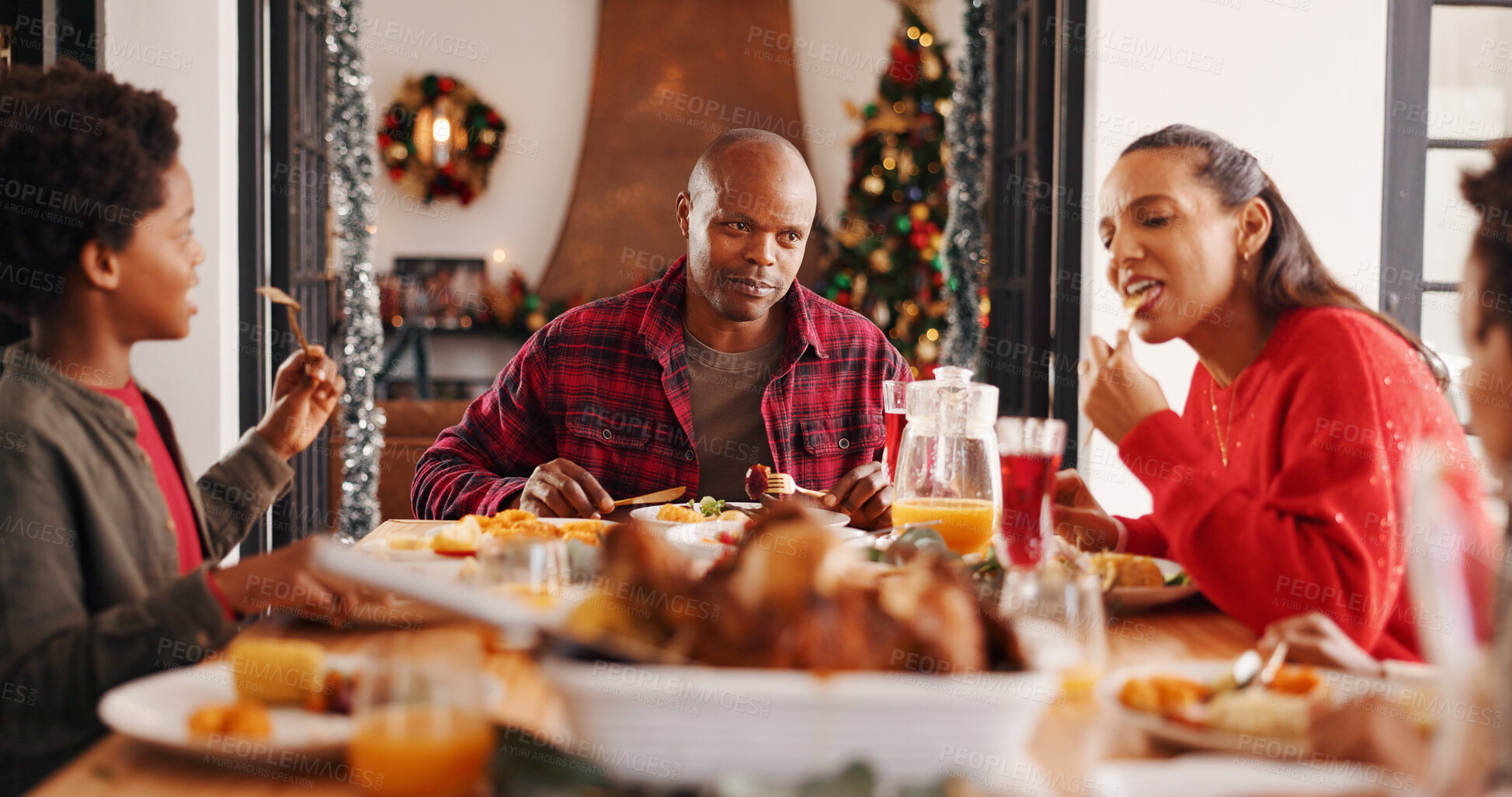 Buy stock photo Christmas food, parents and kids with eating in home for  festive feast, holiday celebration or hungry. People, african family and dining together at table for xmas tradition, brunch meal or bonding