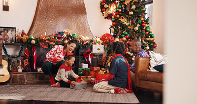 Buy stock photo Excited, African family and gift on Christmas, holiday celebration and bonding together. Smile, parents and giving present to children, xmas tradition and festive season in lounge with kids at house