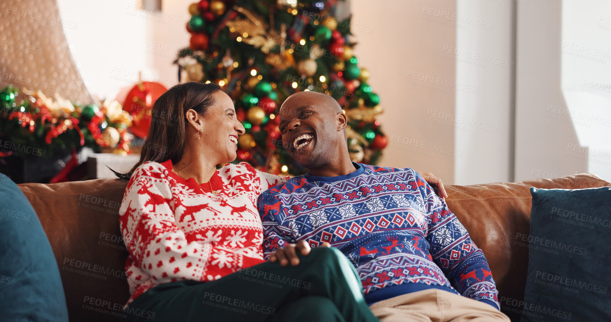 Buy stock photo Christmas, sofa and interracial couple with laugh, tree and love in living room of house together. Joke, smile and man with woman, xmas and holiday or vacation bonding for festive season or tradition