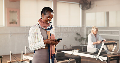 Buy stock photo Pilates class, woman and smile with phone in studio for membership renewal, sign up or website info. Fitness, mature person and happy with mobile app at health club for registration or exercise break