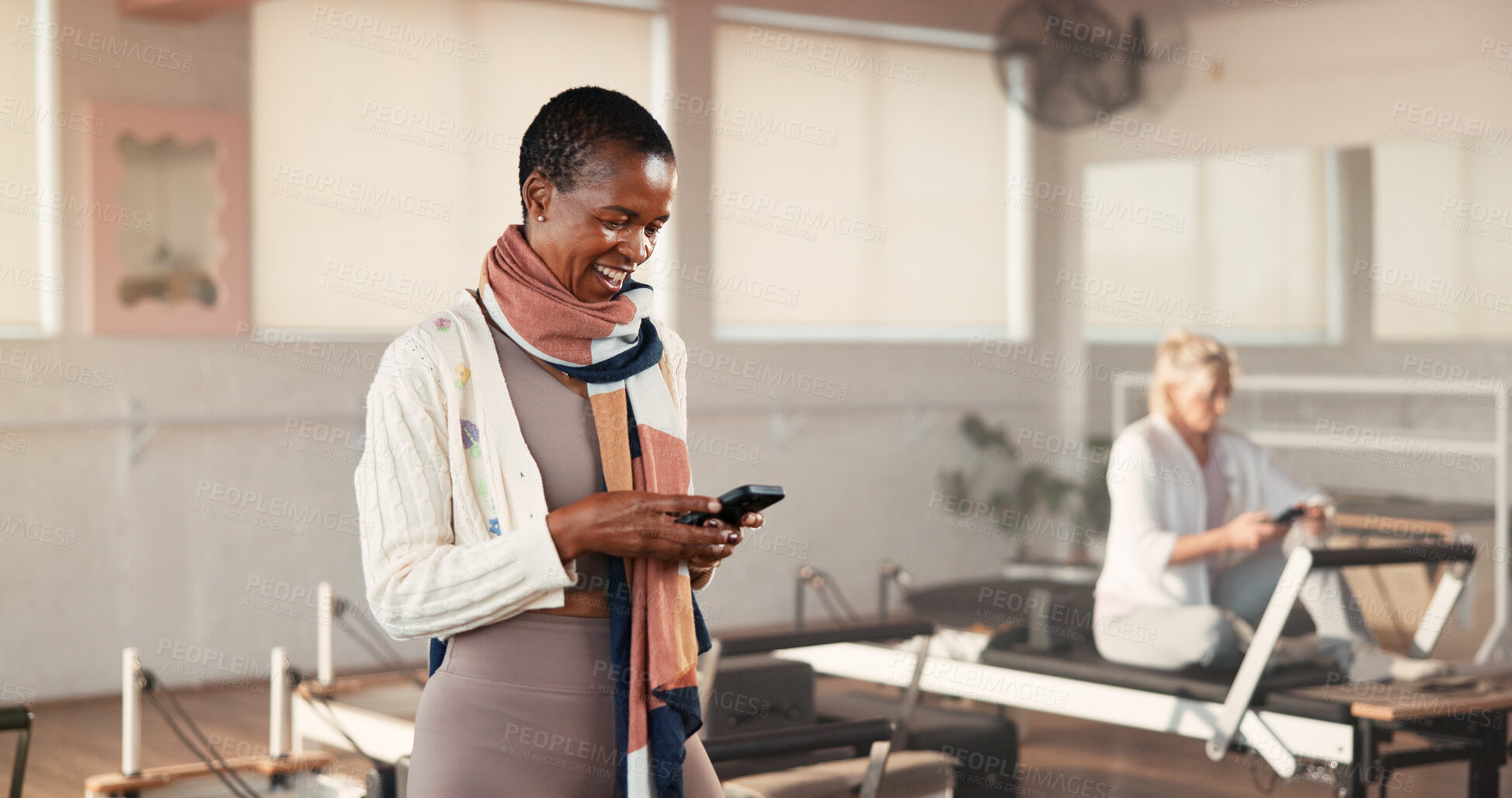 Buy stock photo Pilates class, woman and smile with phone in studio for membership renewal, sign up or website info. Fitness, mature person and happy with mobile app at health club for registration or exercise break