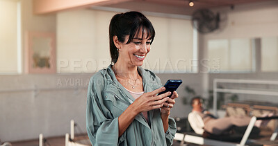 Buy stock photo Pilates, woman and happy with phone in studio for membership renewal, sign up or health progress. Fitness, mature person and smile with mobile app at wellness class for registration or exercise break