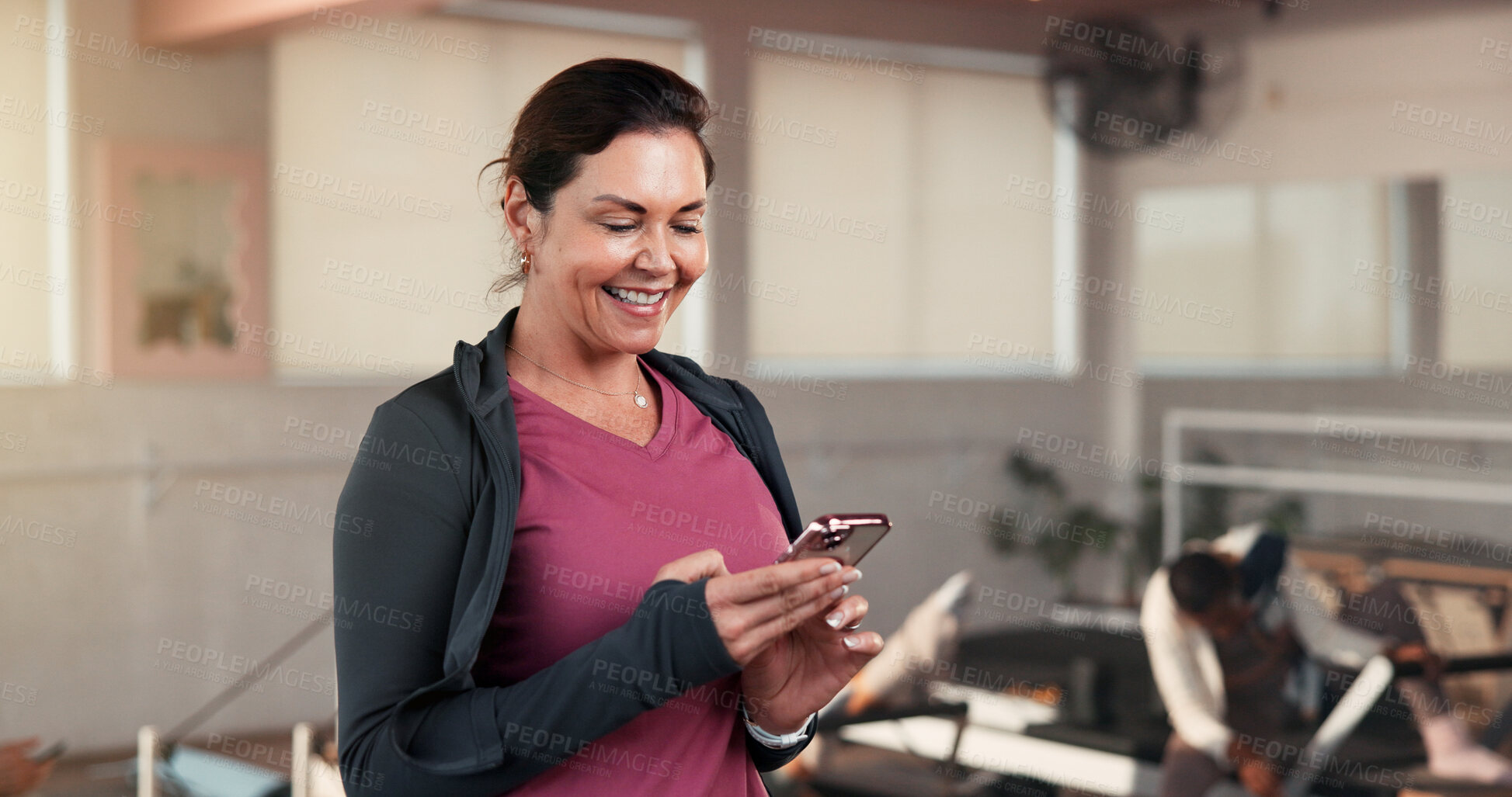 Buy stock photo Pilates class, woman or happy with phone in studio for membership renewal, research or website info. Fitness, mature person or smile with mobile app at health club for exercise rest or online sign up