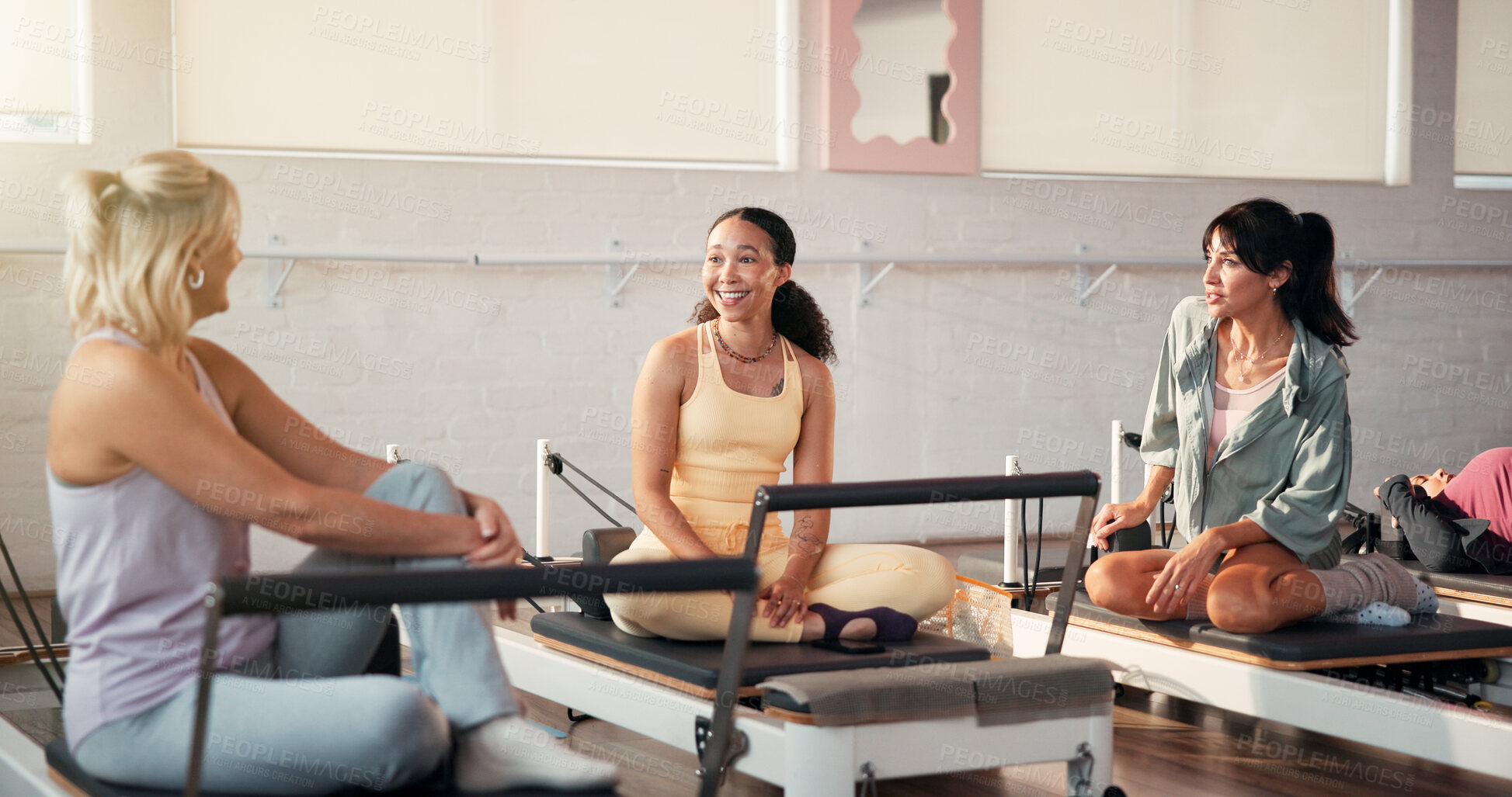 Buy stock photo Pilates, conversation and instructor with women in studio for fitness advice, workout tips or exercise. Health club, trainer and people in discussion, chat or talking on reformer machine for wellness
