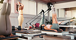Woman, coach and pilates club with stretching legs, reformer and motivation at exercise class. Person, talk and guide for holistic fitness, training instruction or strong with resistance band at gym