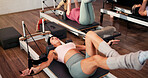Reformer, stretching and woman in studio, exercise and endurance with pilates training. Healthy people, equipment or group in wellness center, machine or fitness with challenge, resistance or balance