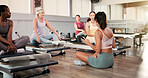 Woman, pilates coach and talk with group on reformer, instruction and attention at exercise class. Person, discussion and guide at studio for holistic fitness, training or listen with tips at gym