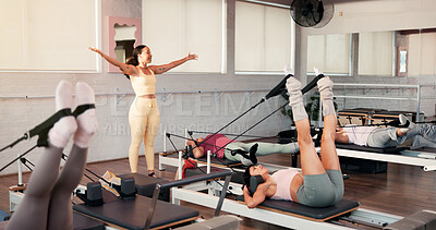 Buy stock photo Woman, coach and pilates class with stretching instruction, reformer and motivation at exercise club. Person, talk and guide for holistic fitness, training legs or workout with resistance band at gym