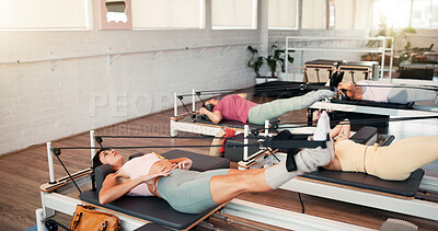 Buy stock photo Reformer, stretching and women in studio, exercise and fitness with pilates training. Healthy people, equipment or group in wellness center, machine or workout with challenge, endurance or resistance