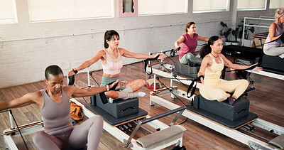 Buy stock photo Women, stretching and pilates class with reformer for flexibility, exercise or training in gym. Active, female people or group with fitness equipment or machine for workout or balance in health club