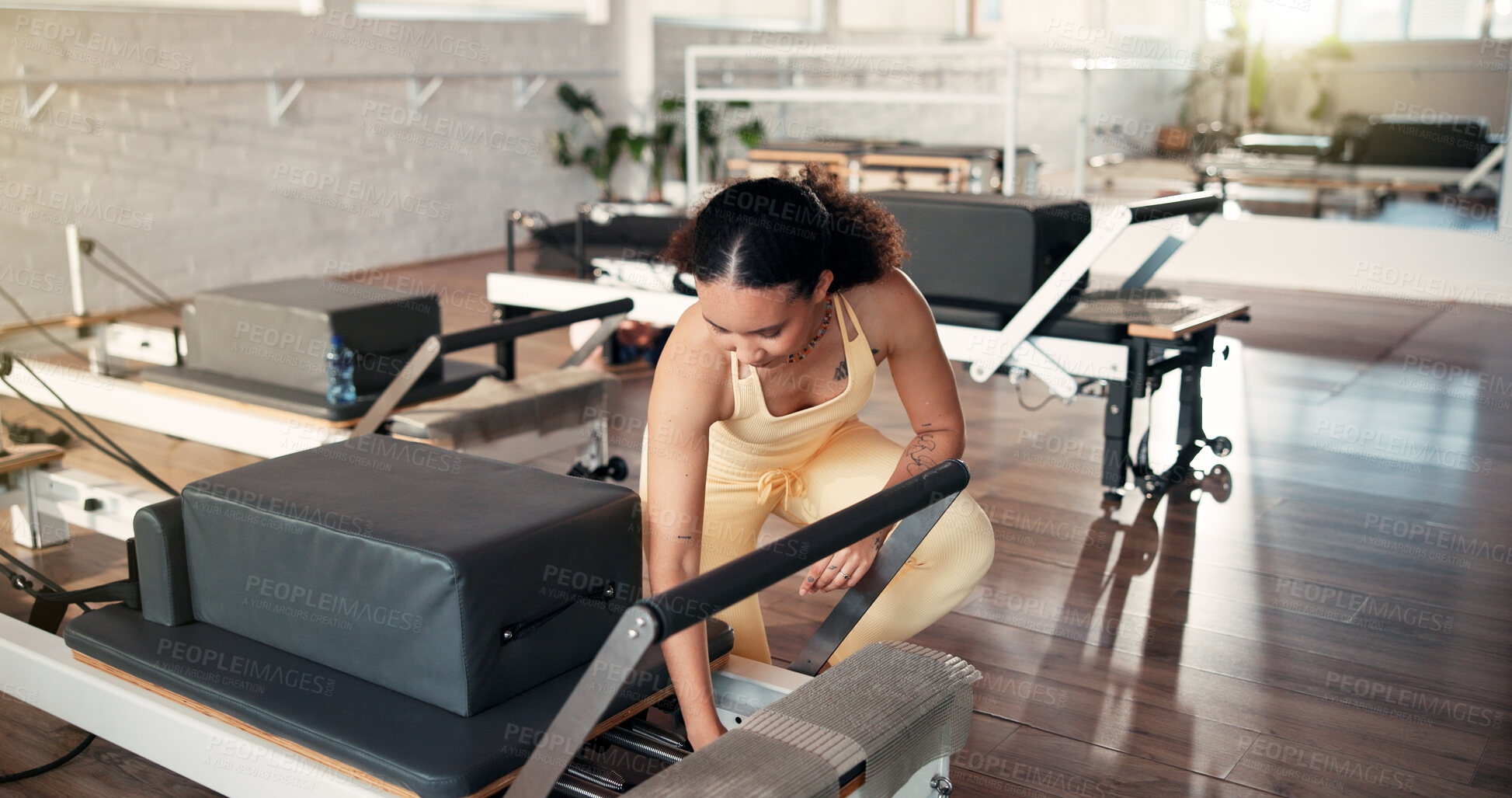 Buy stock photo Safety, inspection and woman with reformer, gym and adjust springs for workout resistance or fitness. Health club, pilates instructor and person with equipment, maintenance and setup for exercise