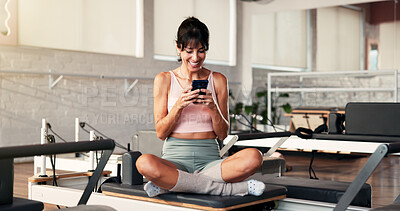 Buy stock photo Reformer, smartphone and happy woman in studio, fitness and typing with digital app to track progress. Healthy, smile and mature person in wellness center, cellphone and social media with connection