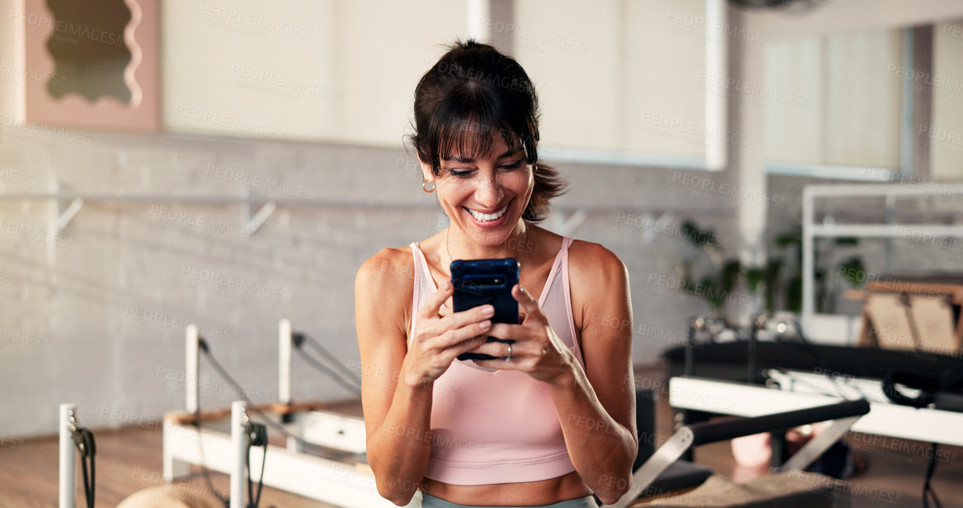 Buy stock photo Smile, smartphone and woman in gym, fitness and typing with digital app to track progress. Happy, mobile user and mature person in studio, cellphone and social media with connection and wellness