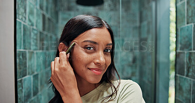 Buy stock photo Skincare, portrait or Indian woman in house with gua sha, facial benefits or massage in self care. POV, jaw tone or girl in bathroom with tool, lymphatic drainage or jade stone for smooth skin.