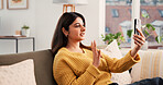 Phone, video call and woman on sofa in house with communication, greeting and online conversation. Happy, waving and female person with cellphone for virtual discussion with networking in living room