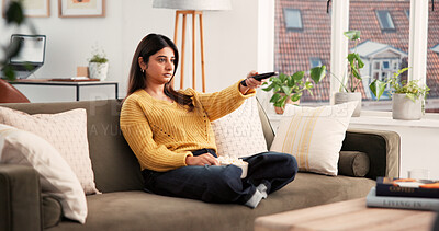 Buy stock photo Home, relax and woman with remote, watching tv and streaming movies with subscription in living room. Channel, change and Indian person with control for entertainment, chill or comfortable on sofa