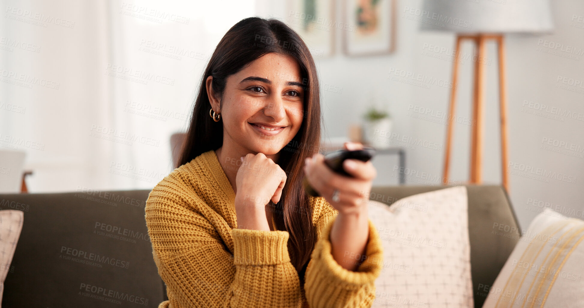 Buy stock photo Streaming, woman and watching tv with remote, lounge and program change on website, happy and relax. Indian person, smile and controller for channel, chill and entertainment with subscription in home