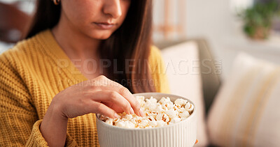 Buy stock photo Woman, hands and eating in apartment with popcorn for holiday, day off and weekend in living room. Female person, relax and chill with snack on couch for vacation break, free time and comfort food.