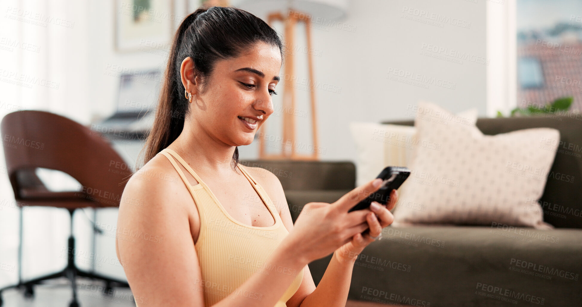 Buy stock photo Woman, phone and fitness with smile in home for online tips, workout app and social media. Internet tutorial, digital exercise guide and reading with person in living room of house for wellness
