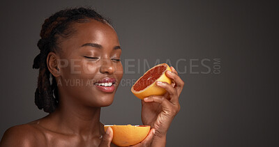 Buy stock photo Skincare, grapefruit and black woman in studio with natural, health or organic facial glow. Vitamin c, space and African female person with citrus fruit for dermatology hydration by gray background.