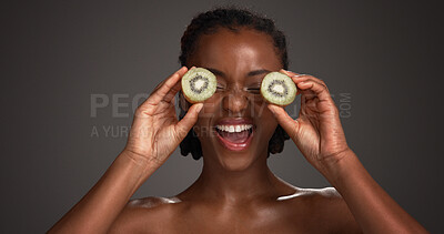 Buy stock photo Skincare, kiwi on eyes and black woman in studio for organic cosmetics, wellness and collagen. Dark background, space and happy person with fruit for natural beauty, vitamins and dermatology benefits