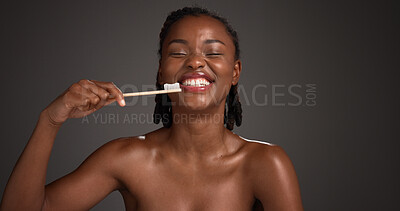 Buy stock photo Black woman, brushing teeth and happy in studio portrait, hygiene and mockup space on dark background. African person, bamboo toothbrush or smile with sustainable product for oral wellness in Nigeria