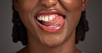 Dental, closeup or black woman in studio with lick, mouth or tooth wellness in orthodontics. Lips, happiness and female person on gray background with hygiene, whitening or dentistry in oral health.