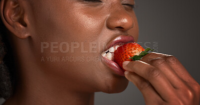 Buy stock photo Beauty, hand and strawberry with black woman in studio for organic benefits of healthy eating. Fruit, nutrition and vitamins with African model on gray background for diet, detox or weight loss